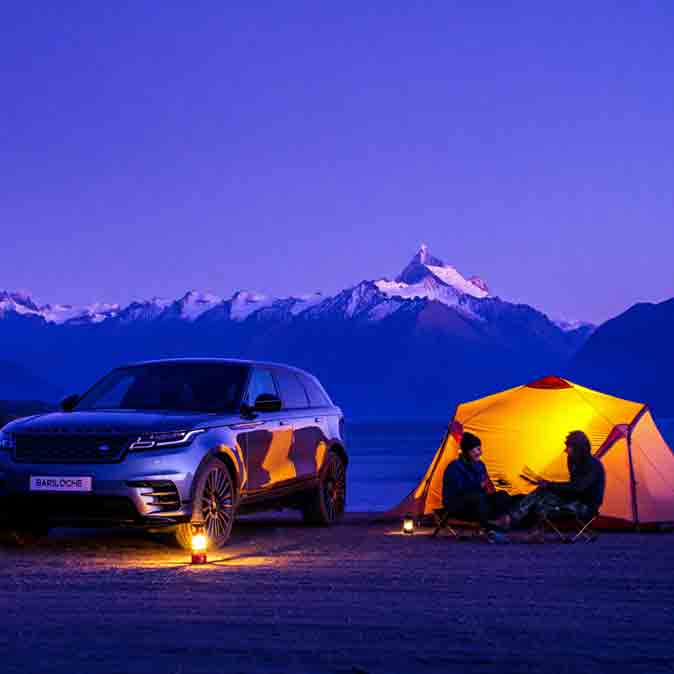 SUV de alquiler en campamento nocturno en San Carlos de Bariloche con montañas de fondo